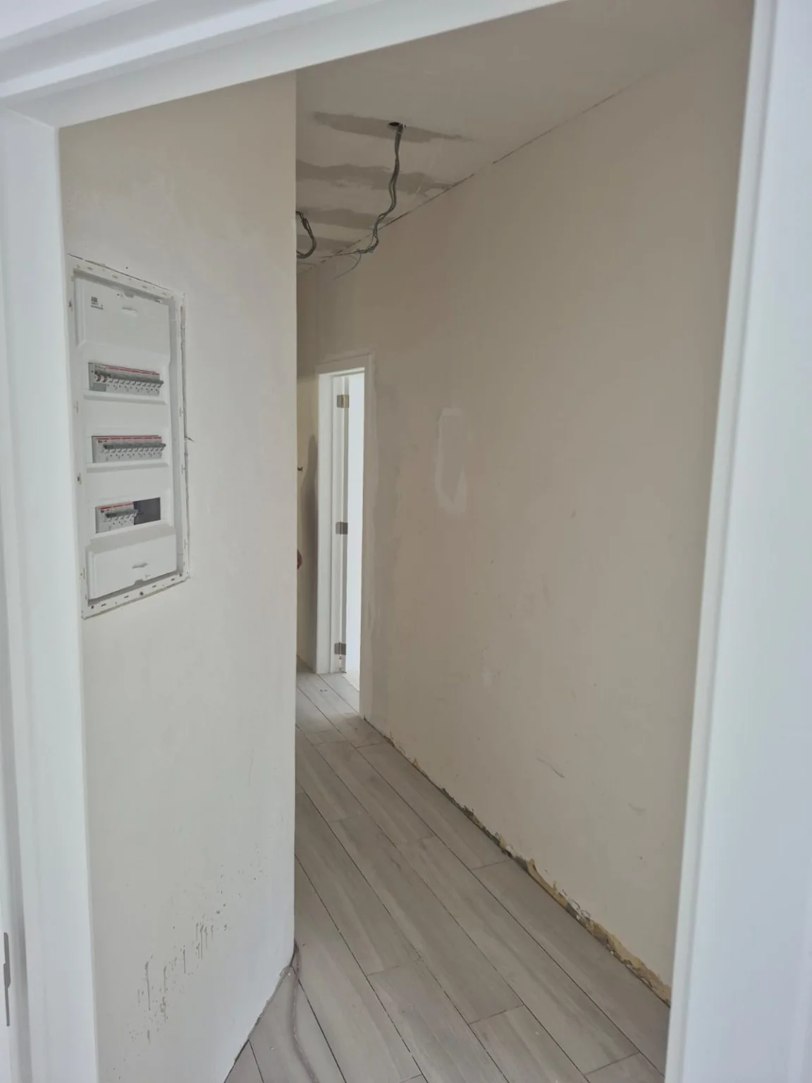 Hall après plafonnage et pose du sol ; finitions en cours