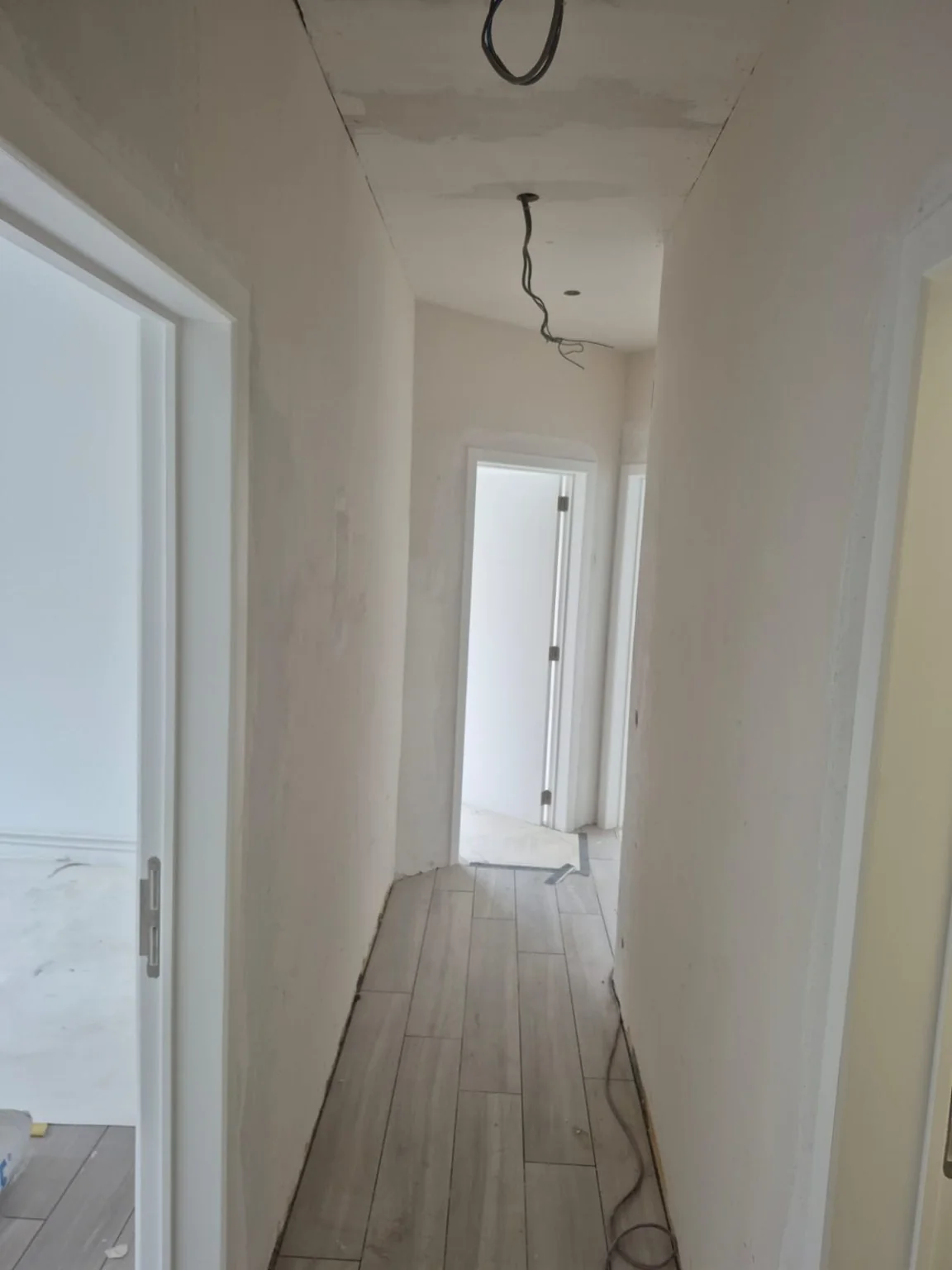 Couloir après pose du sol et des portes ; finitions en cours